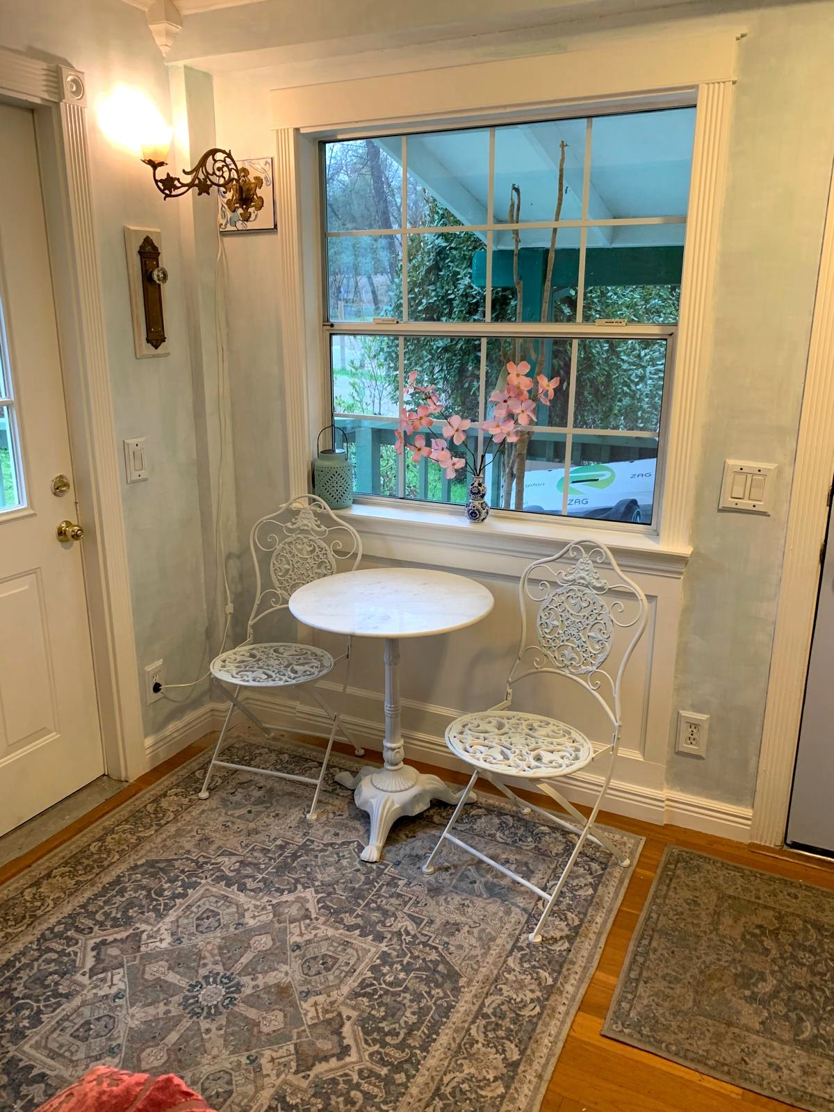Bright finished farmhouse entry with a small bistro table beside the garden window