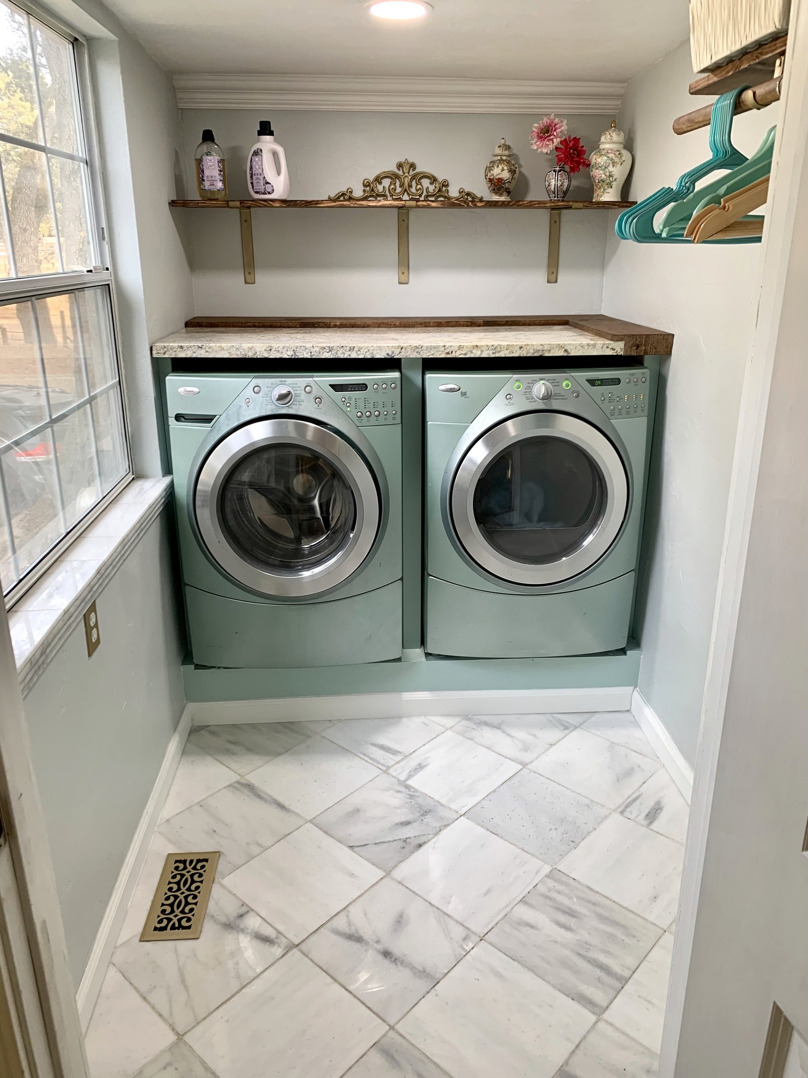 Finished California farmhouse laundry room with marble floor and pale green appliances