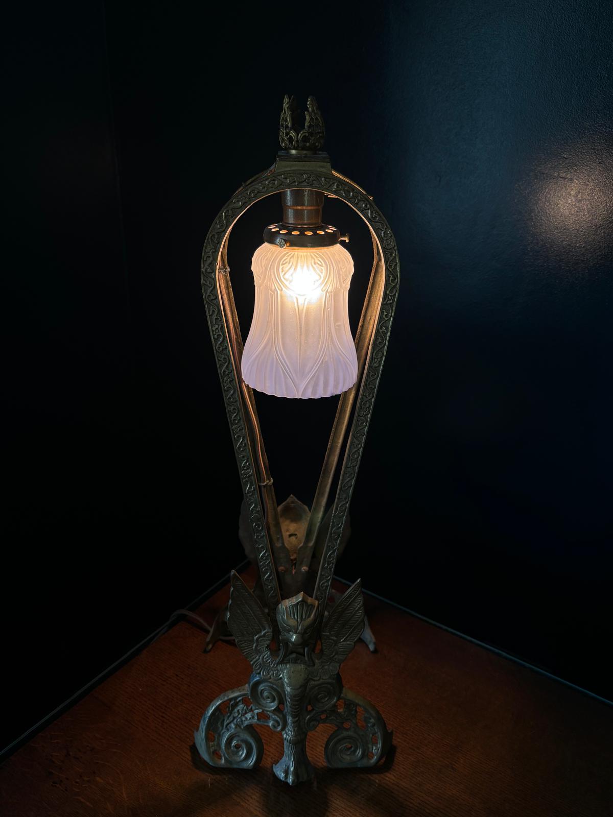 The completed brass fireplace-fan table light illuminated against a dark wall