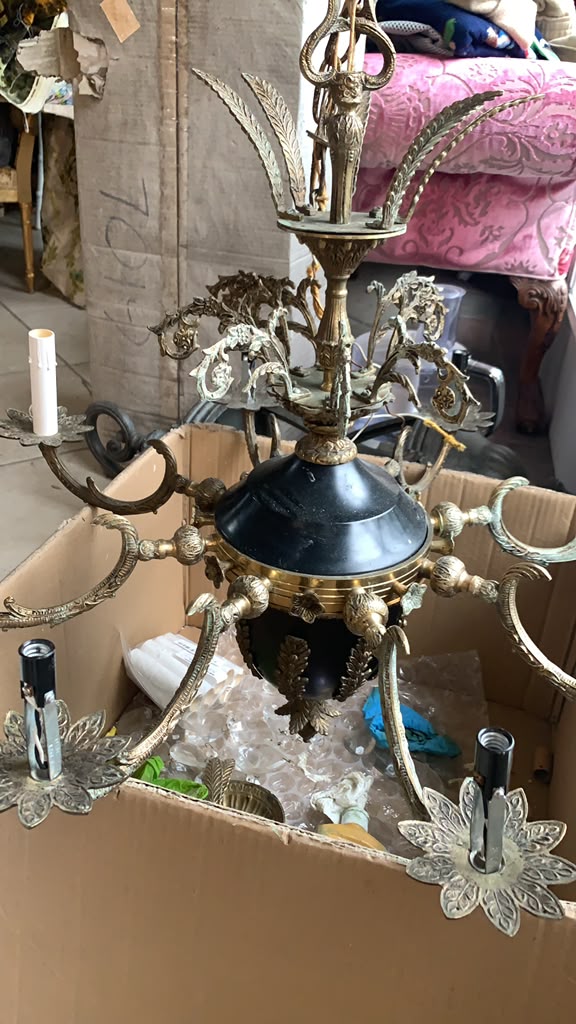Antique chandelier resting in a box during restoration