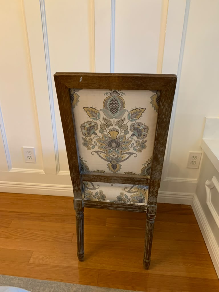 Dining chair with its pale floral upholstery and original wood finish before transformation