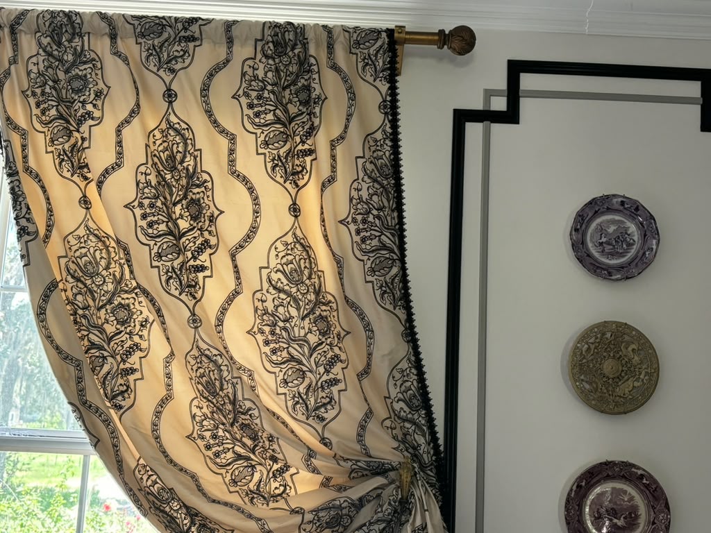 Close detail of the Regent silk drapery, black trim and antique-brass-toned curtain hardware